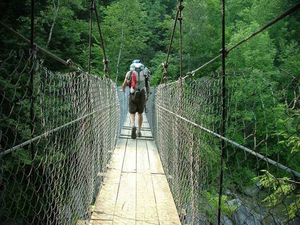 hike the Appalachian trail: Hiker crossing a bridge